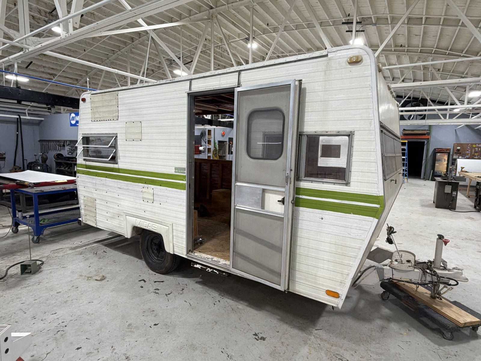 White concession trailer with round windows, hitched to a pickup